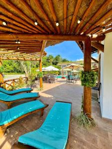 a group of blue lounge chairs under a wooden pergola at Pousada Patuá do Morro in Morro de São Paulo