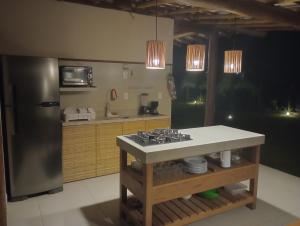 uma cozinha com um fogão e um frigorífico de aço inoxidável em Casa D´Alicia em Maraú