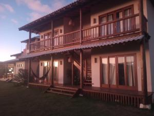 uma casa com uma varanda ao lado em Casa D´Alicia em Maraú