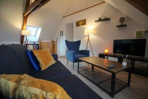 sala de estar con sofá azul y mesa en Au toit de l’Alsace - Loft au pied des Vosges, en Wattwiller