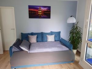 um sofá numa sala de estar com uma fotografia na parede em FeWo mit "Dachterrasse" im Blauen Palais Leipzig em Leipzig