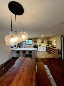 una cocina con 2 luces colgantes y una mesa de madera en Two Bedroom House by Snow Valley Lodging, en Fernie