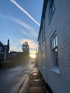 an empty street with the sun setting behind a building at The Traveller's B&B in Louth