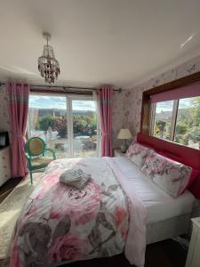 a bedroom with a bed with a floral bedspread and a window at Redwood Lodge in Westbury