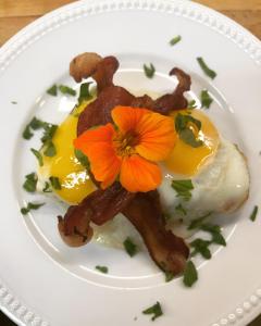 un plato de comida con huevos y una flor en él en Brass Lantern Inn, en Stowe