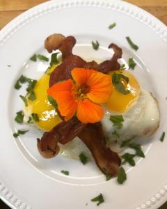a plate of food with eggs and a flower on it at Brass Lantern Inn in Stowe