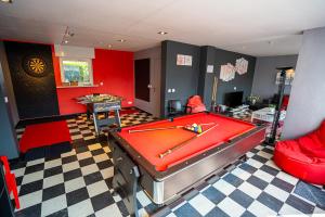 a room with a pool table and red walls at Villa Reunion in Wenduine