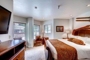 a bedroom with a large bed and a flat screen tv at 4 Bedroom Ski In, Ski Out Mountain Vacation Rental Located Next To Historic Main Street In Downtown Breckenridge in Breckenridge +21 photos