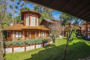 a house with a tower in the middle of a yard at Pousada Boutique Vilage de Minas in Monte Verde