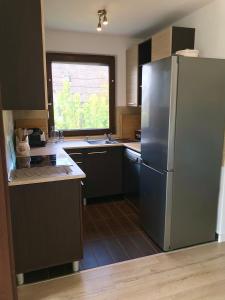 a kitchen with a stainless steel refrigerator and a window at Erkel 19 Apartmanház in Keszthely