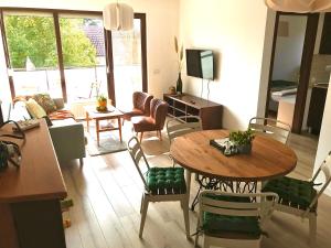 Erkel 19 Apartmanház في كيزتيلي: غرفة معيشة مع طاولة وكراسي خشبية