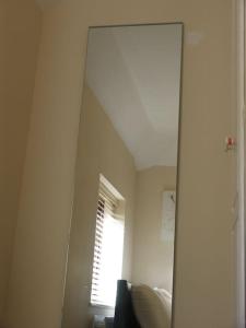a mirror in a room with a window and a couch at Must see, Quality 1 bed, Romford, 20 mins C.London in Romford