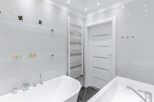 biała łazienka z wanną i umywalką w obiekcie Ratusz Exclusive Apartment- Apartament przy Ratuszu w Głogowie