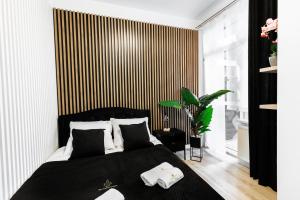 um quarto com uma cama preta e uma parede listrada em Ratusz Exclusive Apartment- Apartament przy Ratuszu em Glogóvia