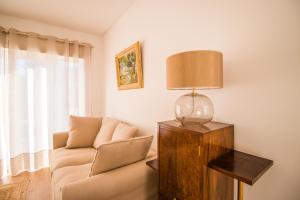 a living room with a couch and a lamp at 188 Apartments - Estrelícia - pool and balcony in Cascais