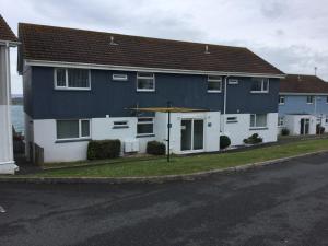a blue and white house with an umbrella on a street at Surf View Apartments in Newquay