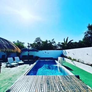 una piscina con terraza de madera y un complejo en Casa mono ambiente y piscina., en Limpio