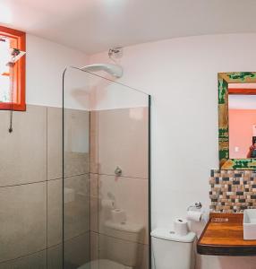 a bathroom with a glass shower and a toilet at Pousada Cordel de Itaúnas in Itaúnas