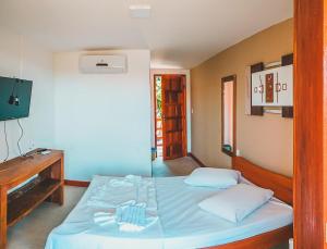a bedroom with a bed and a piano in it at Pousada Cordel de Itaúnas in Itaúnas