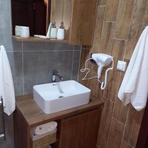 y baño con lavabo blanco y espejo. en Garnet Star Apartments, Kopaonik, apartman br 2, en Kopaonik