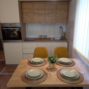 una cucina con tavolo, piatti e bicchieri di Garnet Star Apartments, Kopaonik, apartman br 2 a Kopaonik