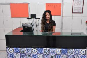 Pousada Aconchego في ساو لويس: امرأة جالسة في مكتب في المطبخ