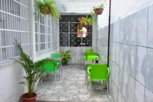 Pousada Aconchego في ساو لويس: فناء مع كراسي خضراء وطاولات في مبنى