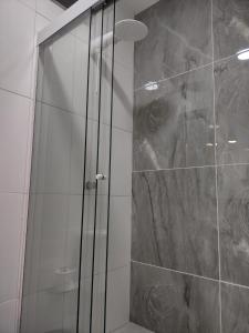 a shower with a glass door in a bathroom at Ipê Suítes in Domingos Martins