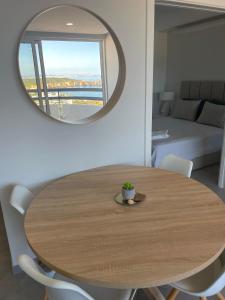 - une table ronde en bois avec des chaises et un miroir dans l'établissement Sunset SeaView Apartment 18 - Torre Verde, à Portimão