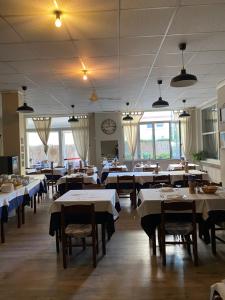 a dining room with tables and chairs and a clock at Hotel La Pergola in Loano