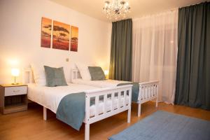 a bedroom with two beds and a chandelier at Große Wohnung, 100 qm mit Terrasse in Alzenau in Unterfranken