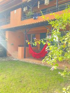a house with a red hammock outside of it at Charmoso apartamento na Herdade da Aroeira in Aroeira