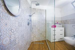 ein Bad mit einer Dusche, einem Waschbecken und einem Spiegel in der Unterkunft Le Volte Apartments in Torchiarolo