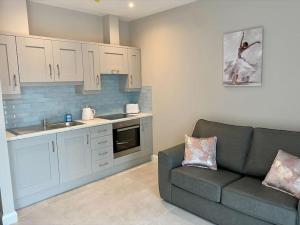 a living room with a couch and a kitchen at Erne Getaway No.6 Brand new 1 bed apartment in Enniskillen