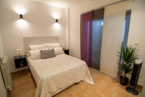 1 dormitorio con 1 cama con sábanas y almohadas blancas en Santorini - Blue Dream Alacant - 1, en Gran Alacant
