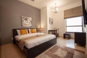 een slaapkamer met een groot bed en een raam bij Modern, Luxe & Spacious 4-Bed Condo, Full Kitchen, 3 Min walk to Beach, Tram & Marina By "La Buena Vida Holiday Homes" in Dubai