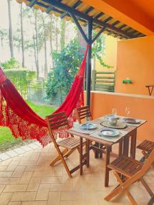 un patio con mesa, sillas y hamaca en Charmoso apartamento na Herdade da Aroeira en Aroeira