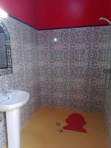 a bathroom with a sink and a red ceiling at AUBERGE DES ANGES in Zrigat