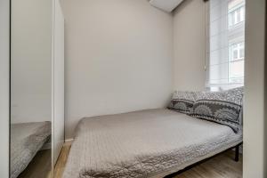 a small bedroom with a bed and a window at Central Platinum Apartments 8 in Rybnik