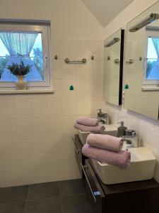 ein Bad mit 2 Waschbecken, einem Spiegel und einem Fenster in der Unterkunft Dům na Lipně in Lipno nad Vltavou