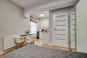 a bedroom with a bed and a table and chairs at Central Platinum Apartments 18 Studio z aneksem kuchennym i tarasem - 3 łóżka in Rybnik