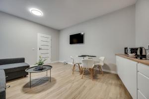 a kitchen and a living room with a table and chairs at Central Platinum Apartments 22 in Rybnik