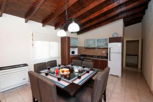 Complejo de cabañas Atrapasueños في إل كالافاتي: مطبخ وغرفة طعام مع طاولة وكراسي