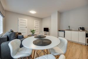 salon z białym stołem i białymi krzesłami w obiekcie Central Platinum Apartments 21 w Rybniku