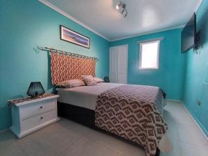 Un dormitorio con una cama con paredes azules y una ventana en Bello y cómodo departamento a minutos del centro, en Santiago