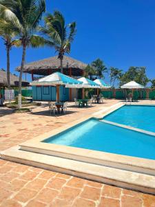 una piscina con sombrillas y un complejo en Puerto Blanco Marina & Hotel en Puerto de Luperon