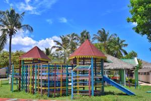 un parque infantil con 2 estructuras de juego y un tobogán en Puerto Blanco Marina & Hotel en Puerto de Luperon