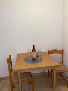 a bottle of wine sitting on a table with two glasses at zolina in Tivat