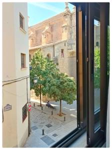 a window view of a tree and a building at Santo Domingo Suites in Granada