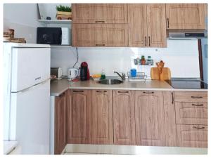 グラナダにあるSanto Domingo Suitesのキッチン(木製キャビネット、白い冷蔵庫付)